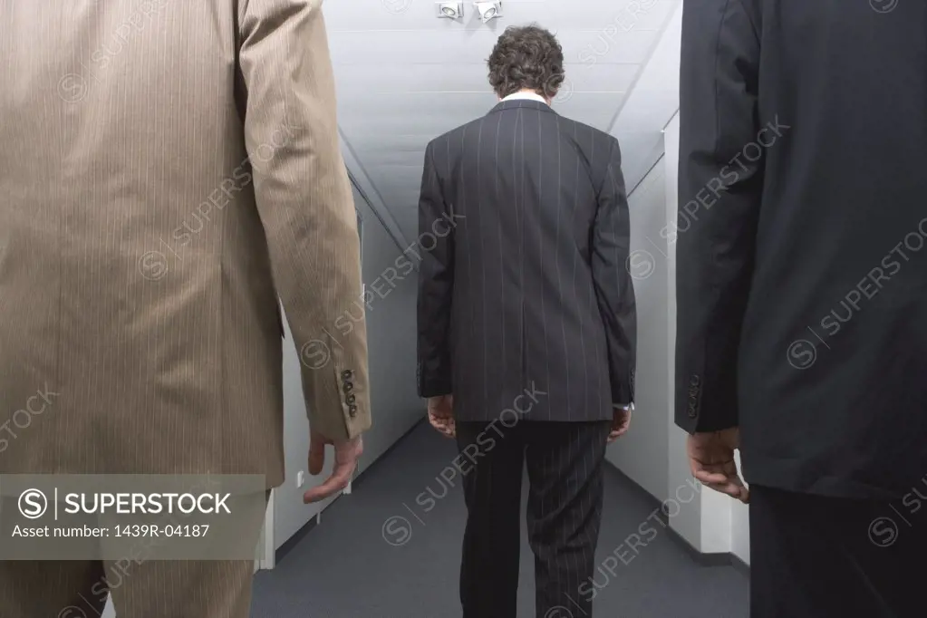 Three businessmen standing in corridor