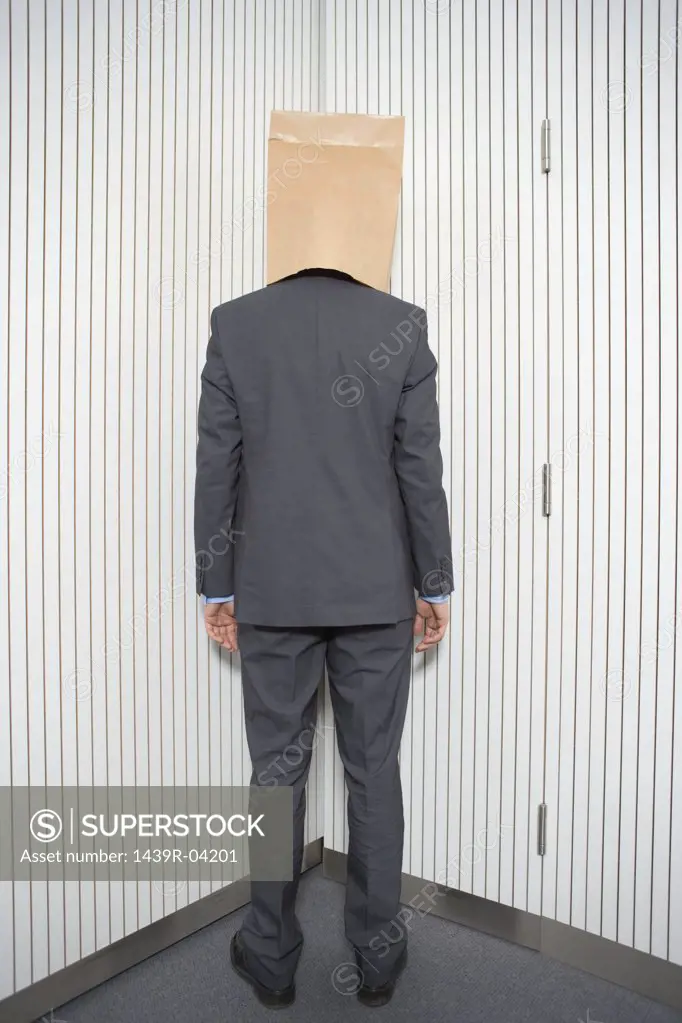 Businessman with paper bag on head