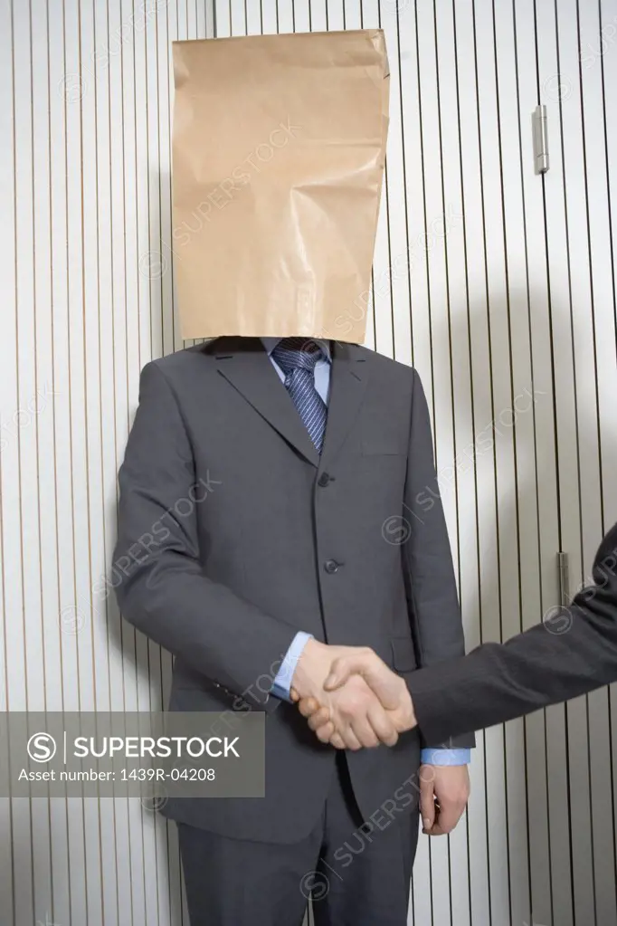 Businessman with paper bag on head