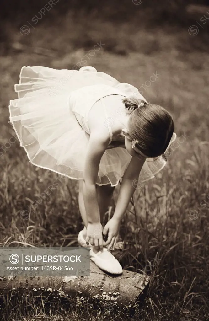 Girl adjusting her ballet slipper