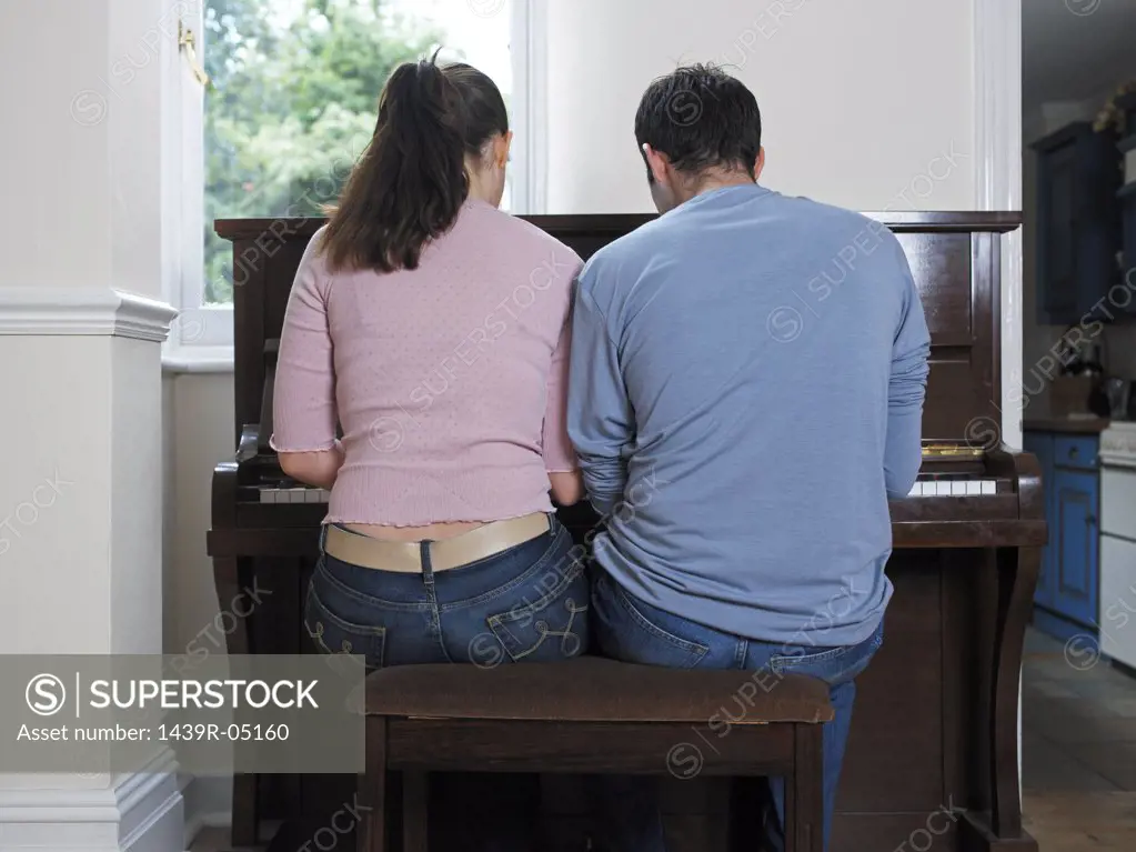 Young couple playing the piano