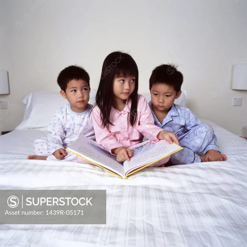 Children on bed with book