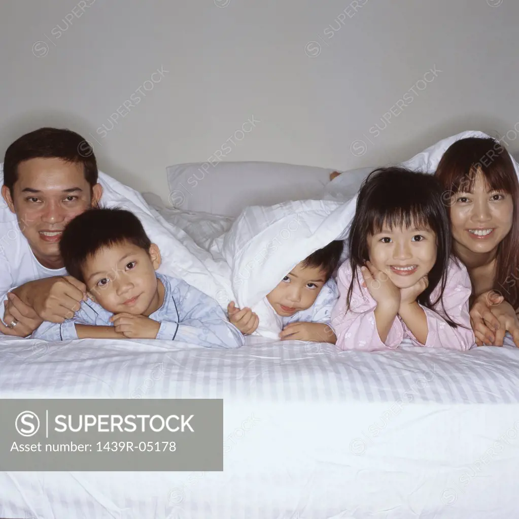 Happy young family in bed