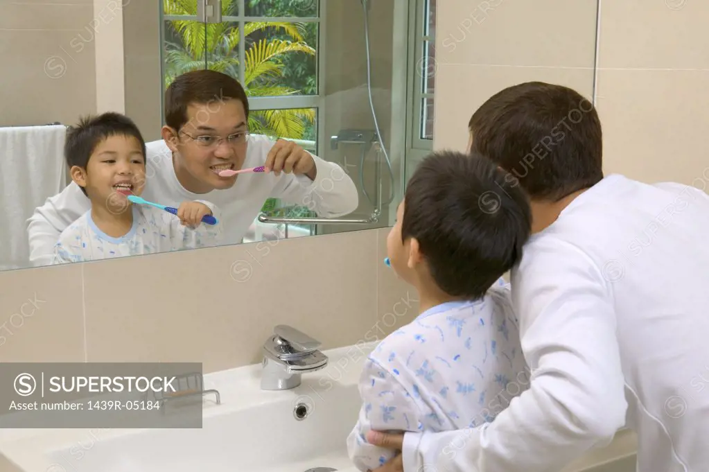 Father and son brushing teeth