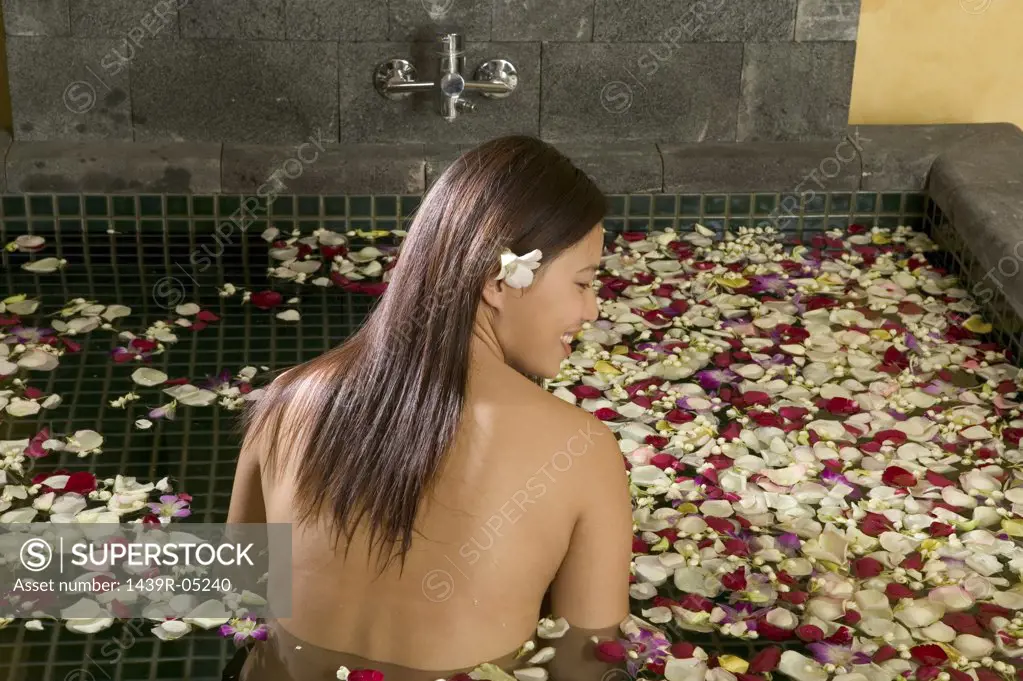 Woman in bath with petals