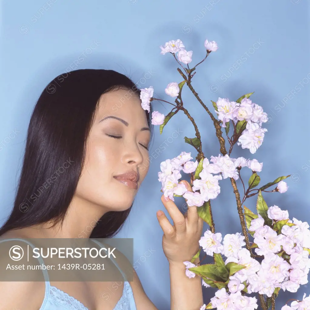 Young woman sniffing blossom