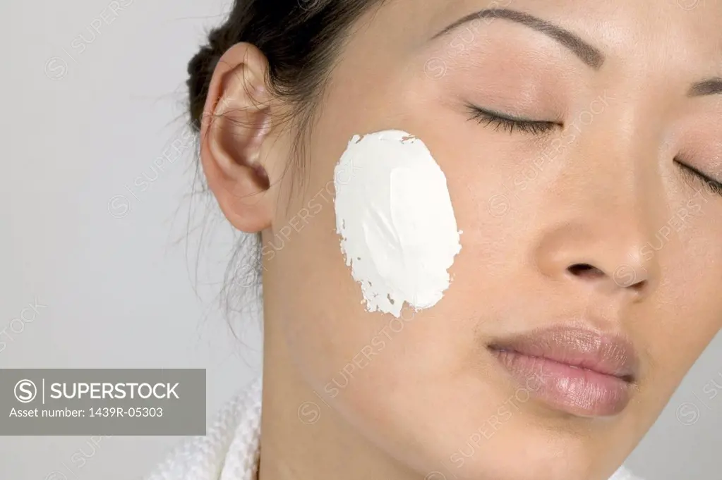 Woman with moisturiser on cheek