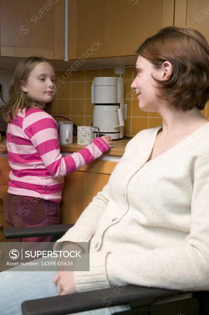 Disabled mother and daughter in kitchen