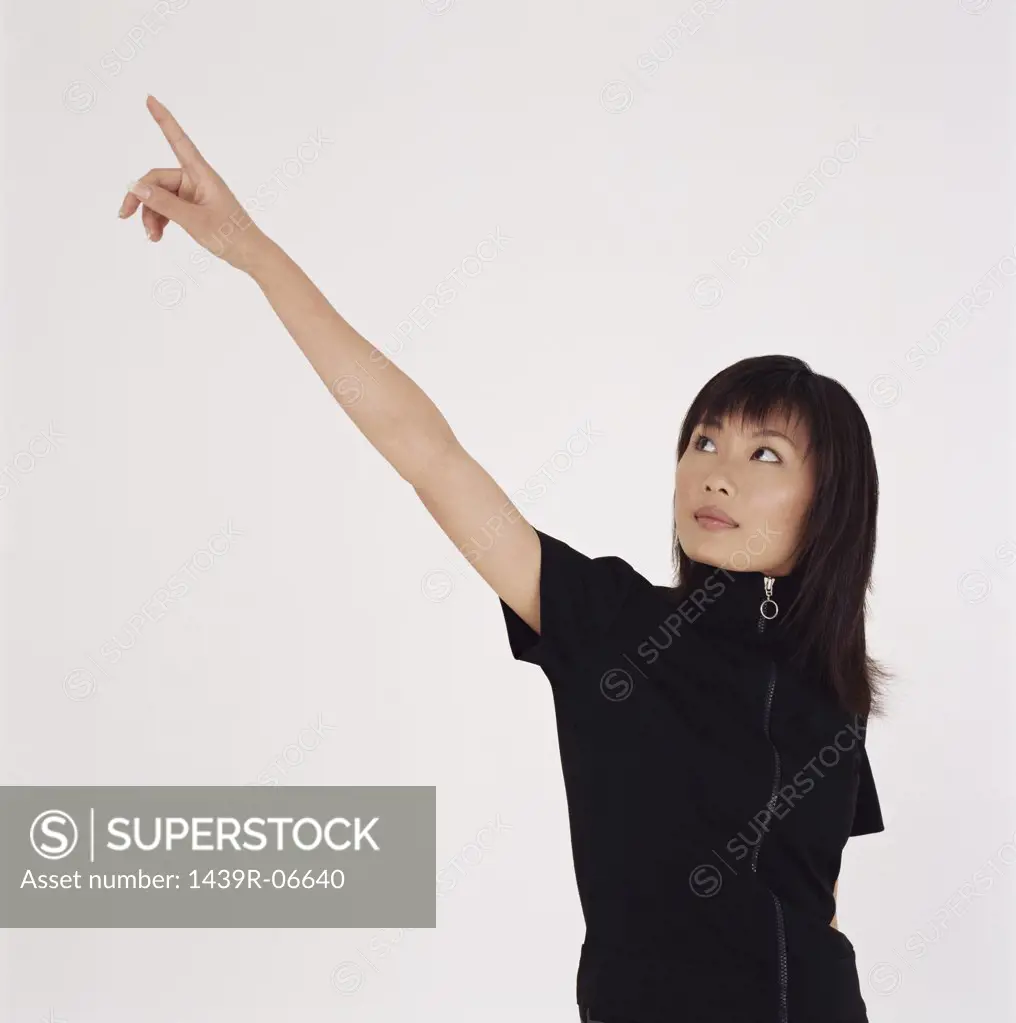 Young woman pointing upwards