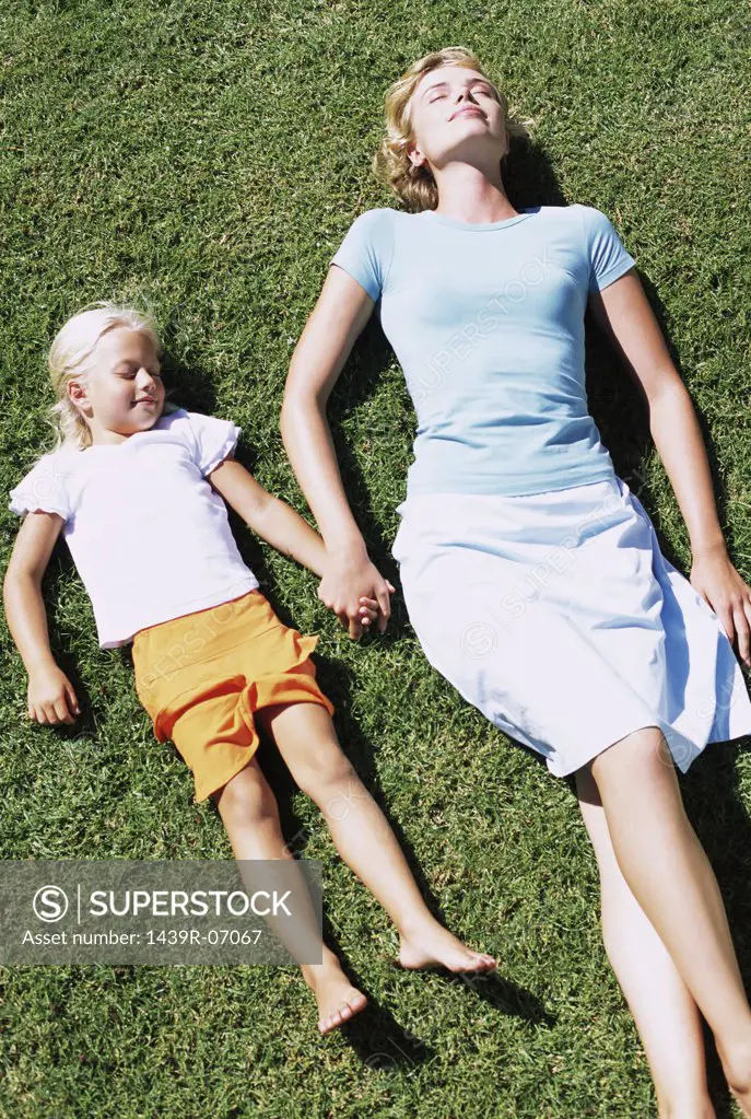 Mother and daughter asleep on lawn