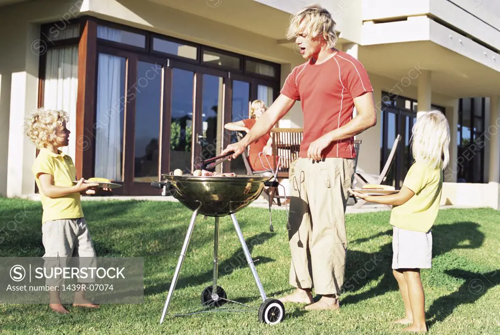 Father doing a barbecue for his family