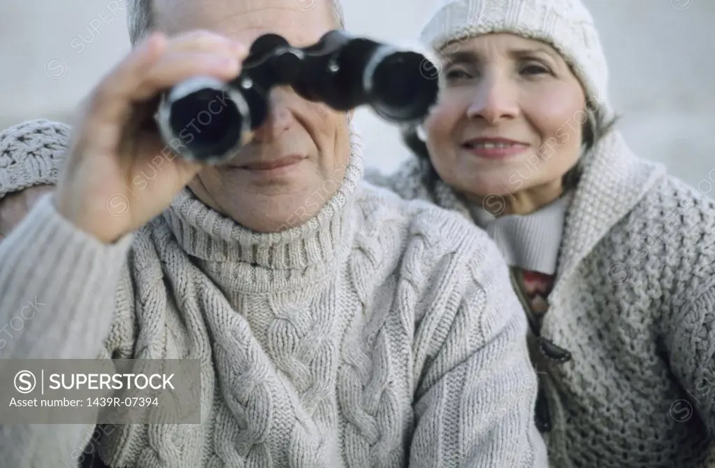 Senior couple using binoculars