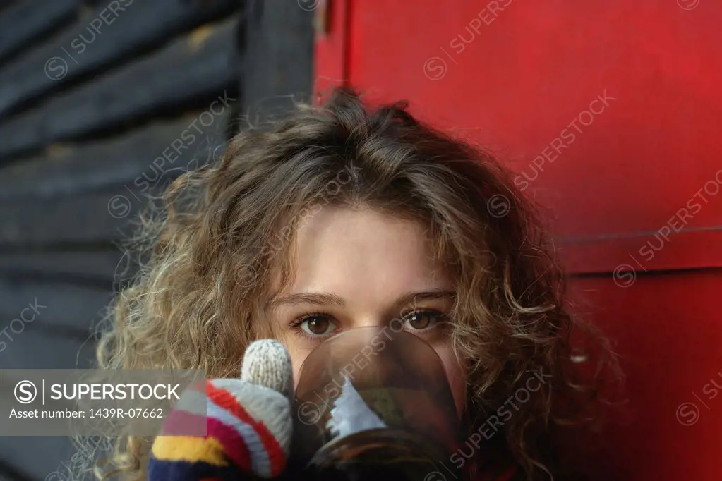 Woman in gloves drinking 
