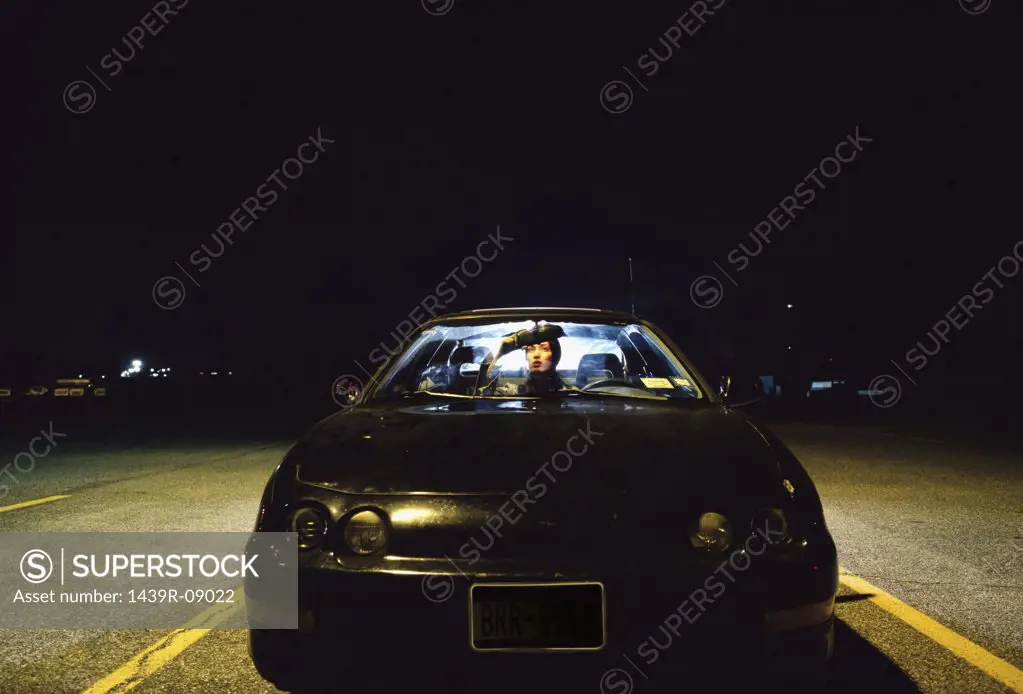 Woman sitting in car at night