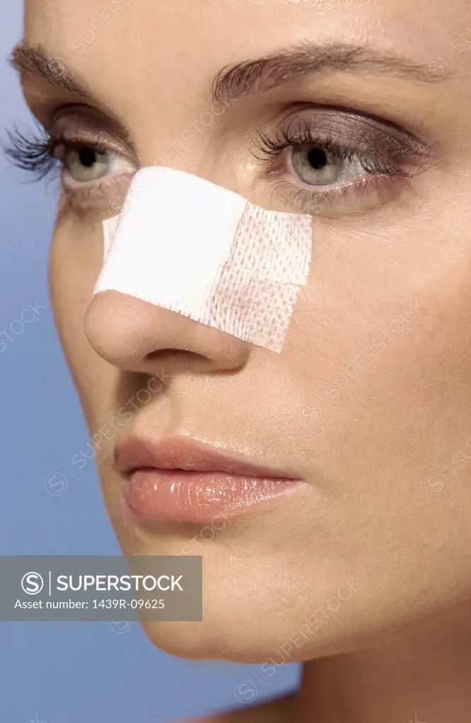 Woman wearing an adhesive plaster on face