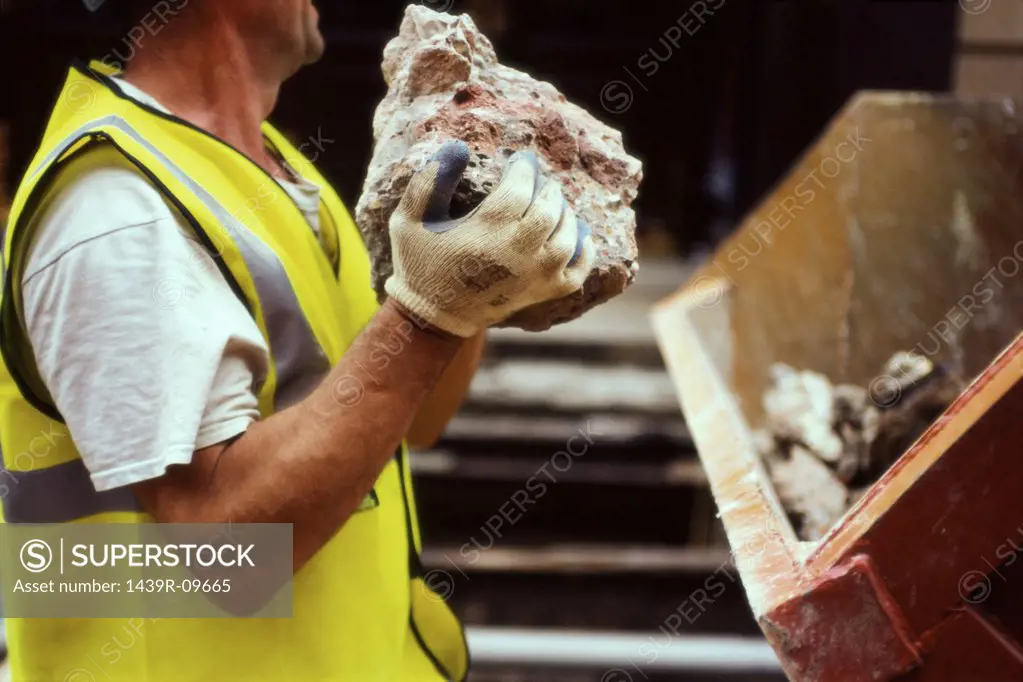 Construction worker holding rubble