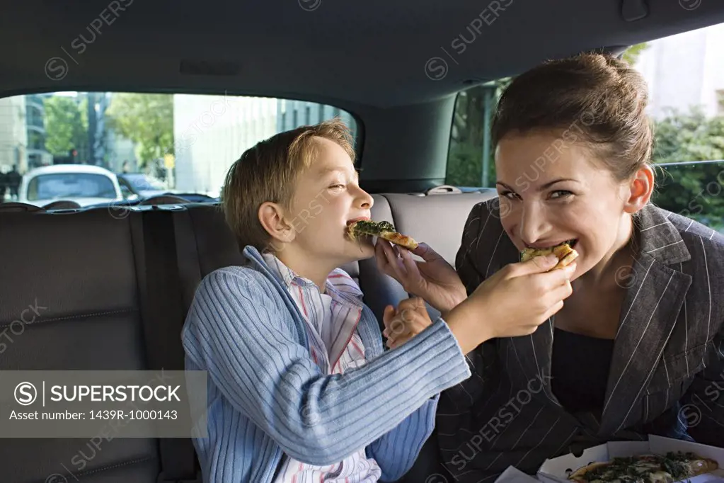 Mother and son eating in car