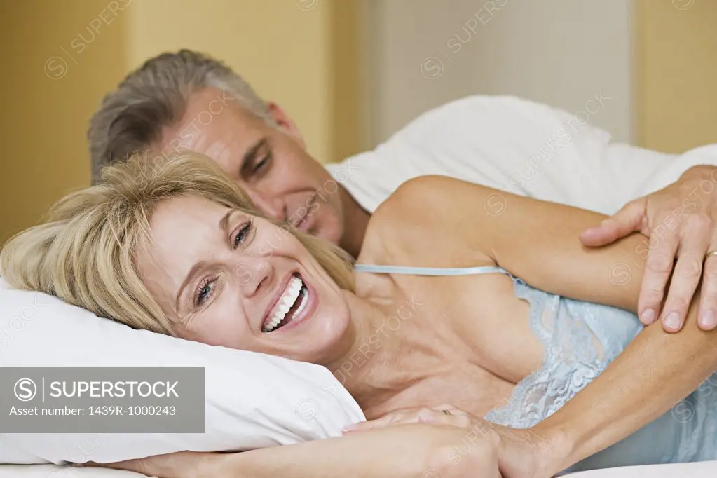 Happy couple lying on bed