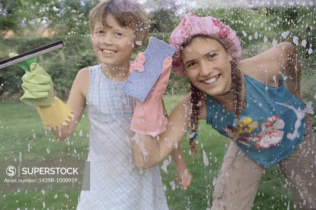 Two girls cleaning window