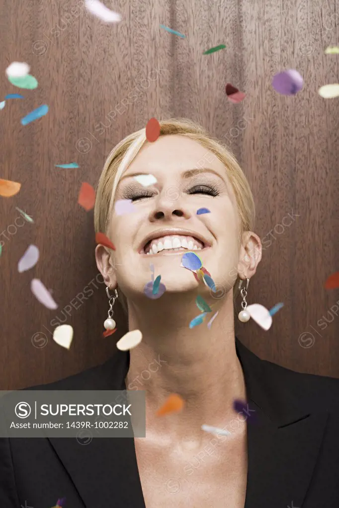 Businesswoman under falling confetti