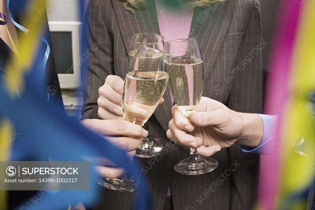 Office workers toasting with champagne