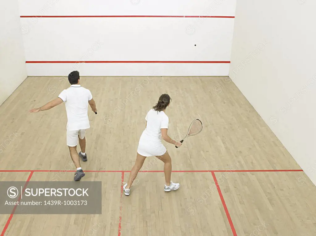 Man and woman playing squash