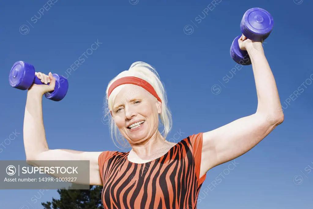 Senior adult woman lifting dumbbells