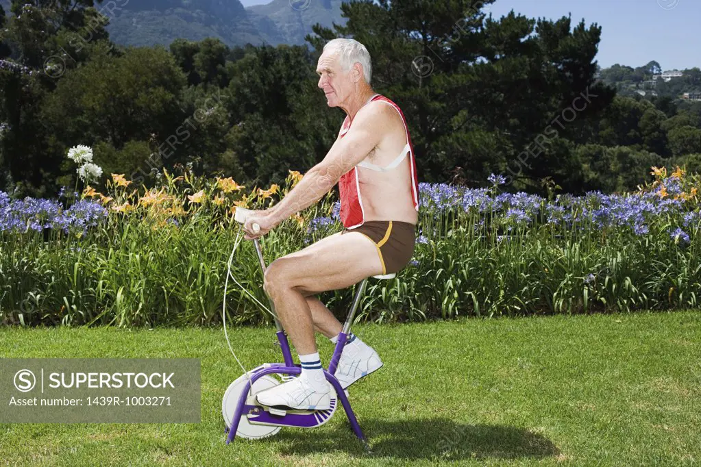 Senior adult man riding exercise bike