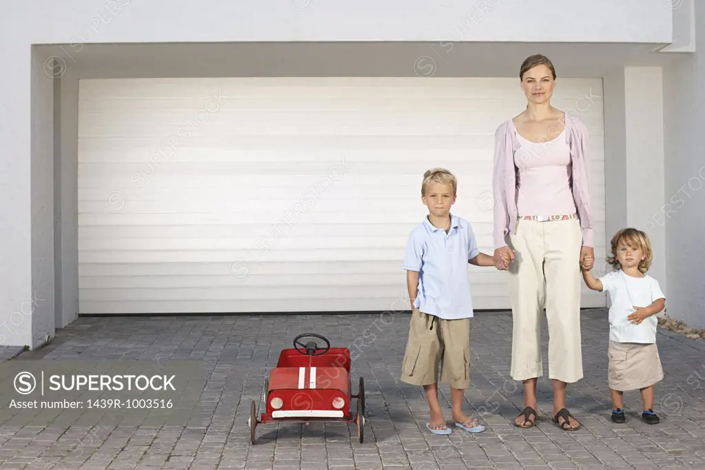 Mother and children stood outside garage