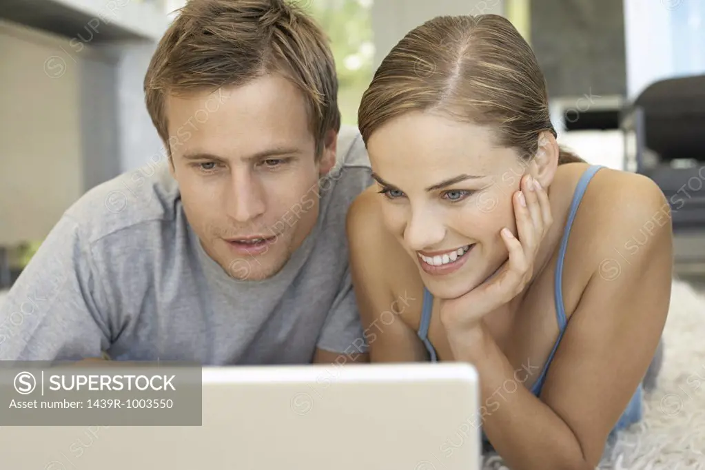 Mid adult couple using laptop