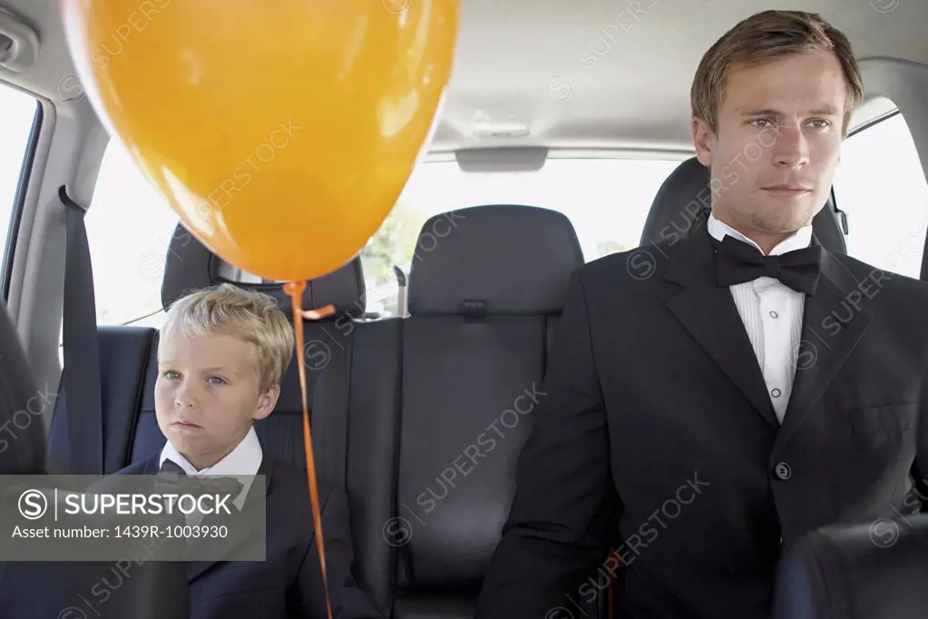 Man and boy in a car wearing dinner jackets