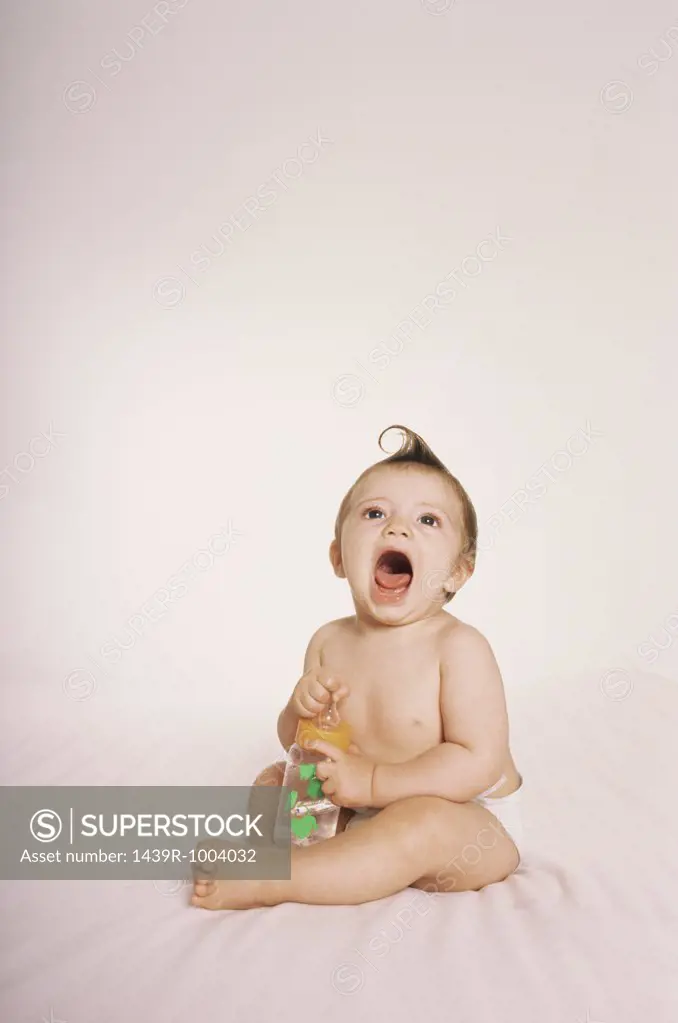 Baby holding baby bottle
