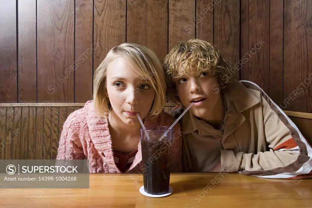Teenage couple sharing a soft drink