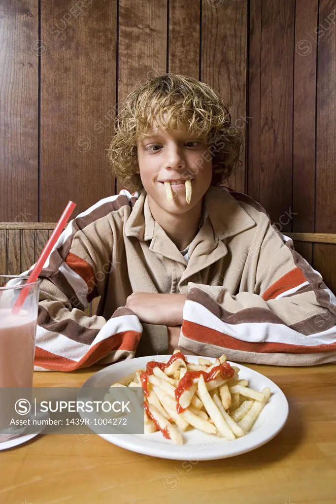 Teenage boy playing with his food