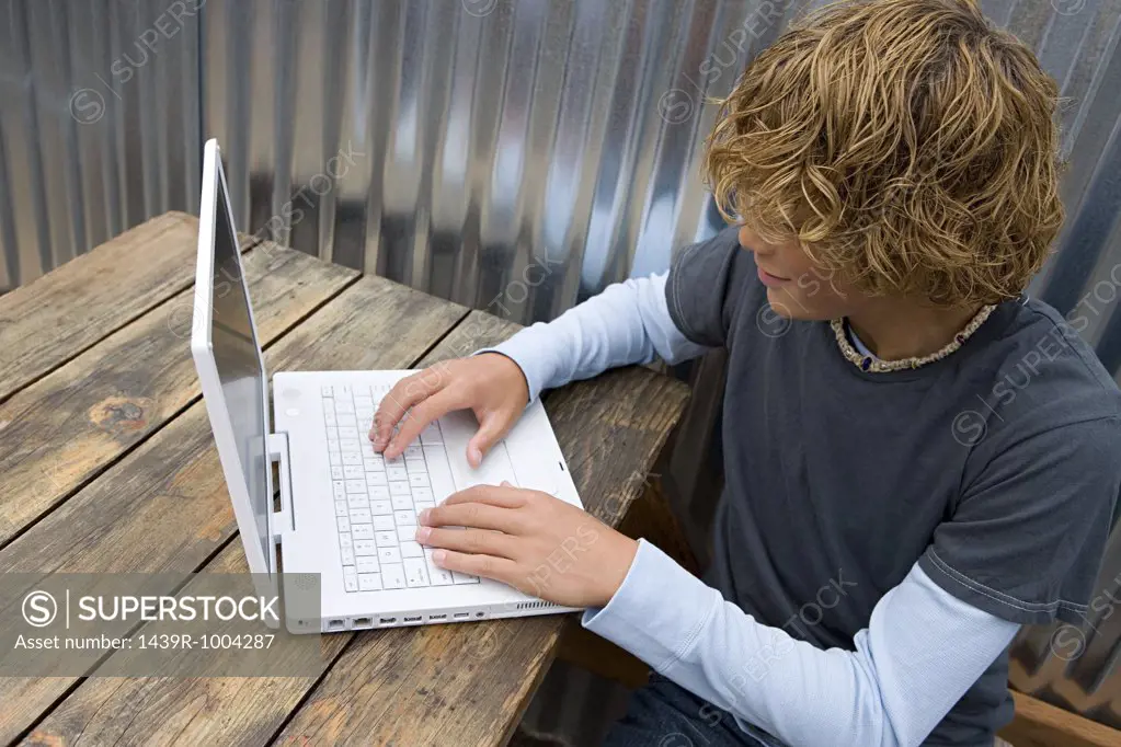 Teenage boy working on a laptop computer