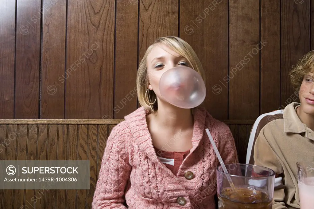 Teenage girl blowing a bubble