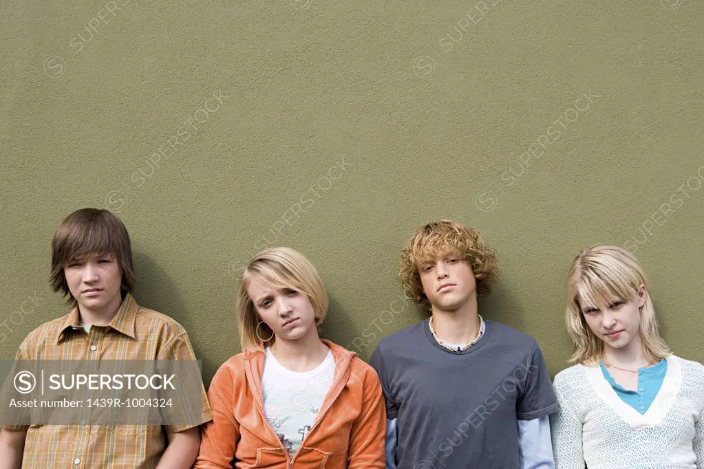 Four teenagers leaning against wall