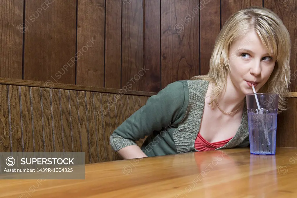 Teenage girl drinking soda in a cafe