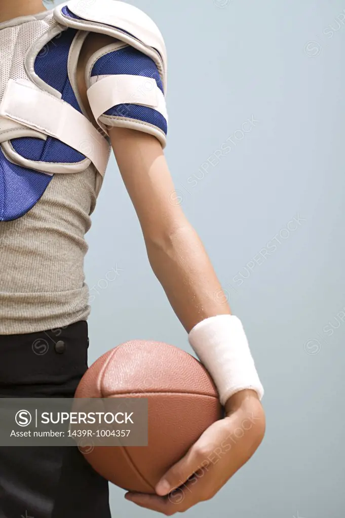 Teenage boy holding an american football