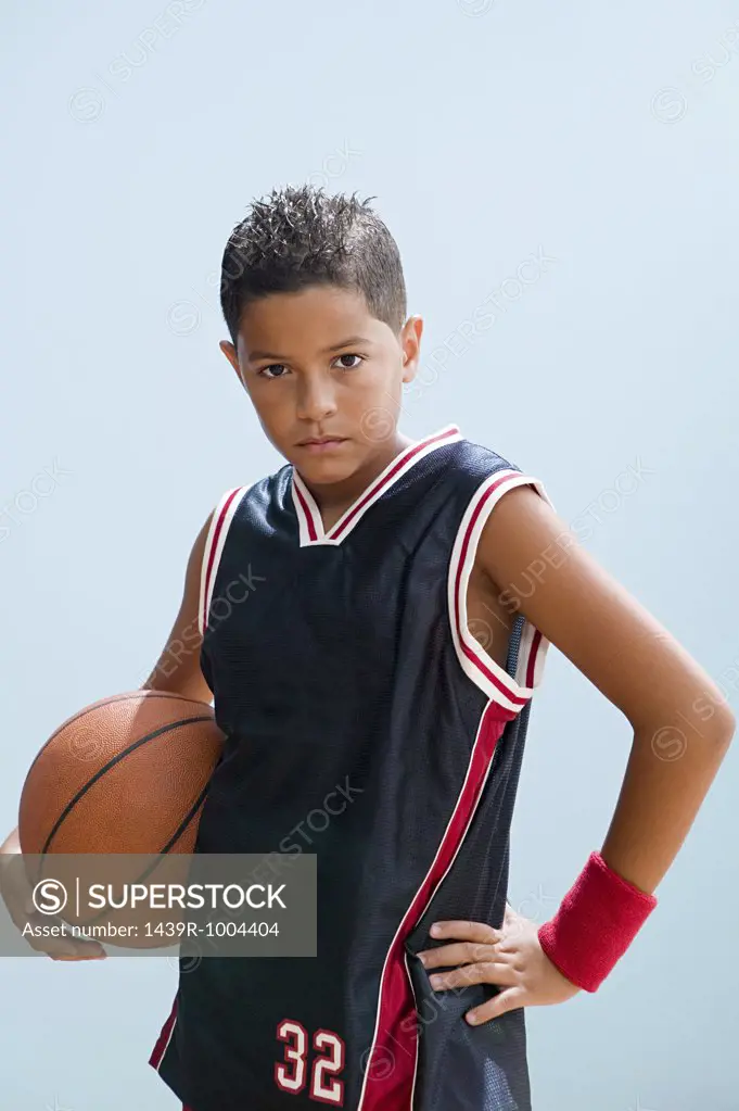 Boy in basketball uniform holding basketball