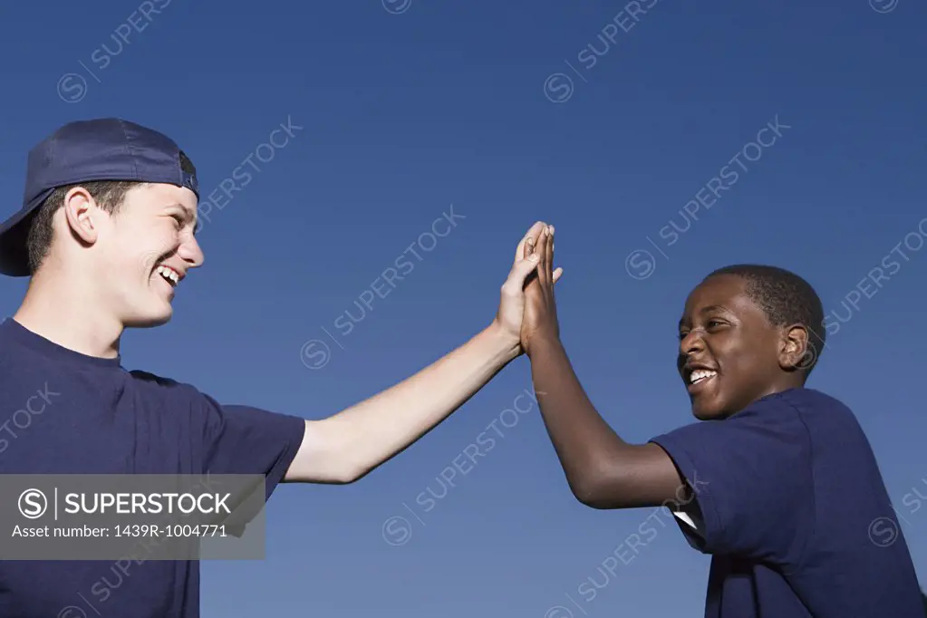 Two teenage boys giving a high five