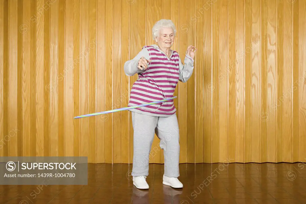 Senior woman exercising with a hula hoop