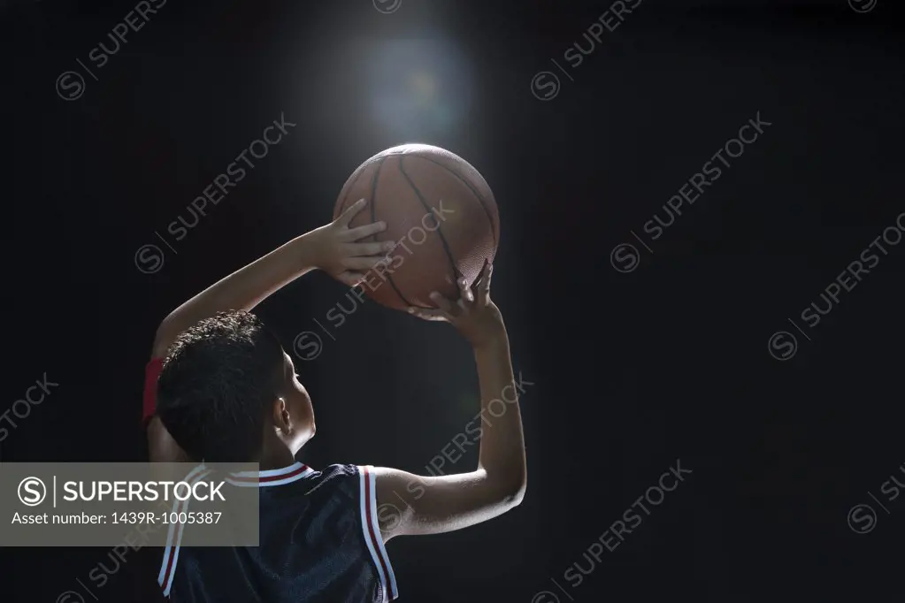 Illuminated boy with basketball