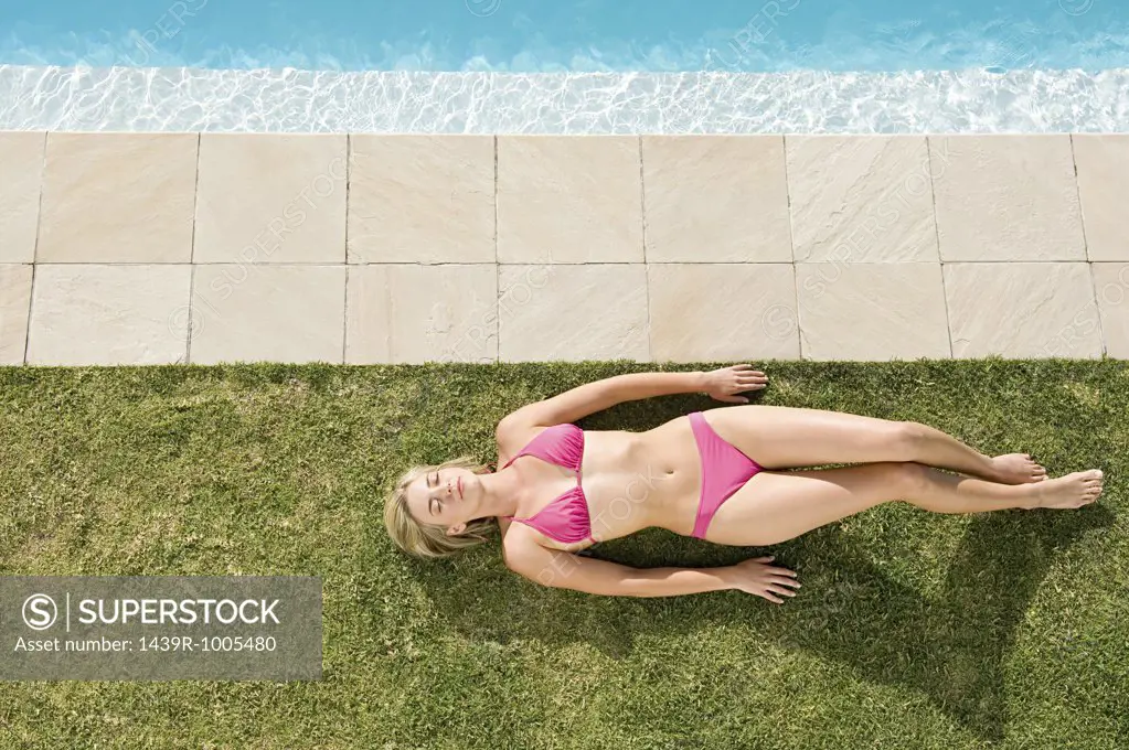 Woman sunbathing by pool