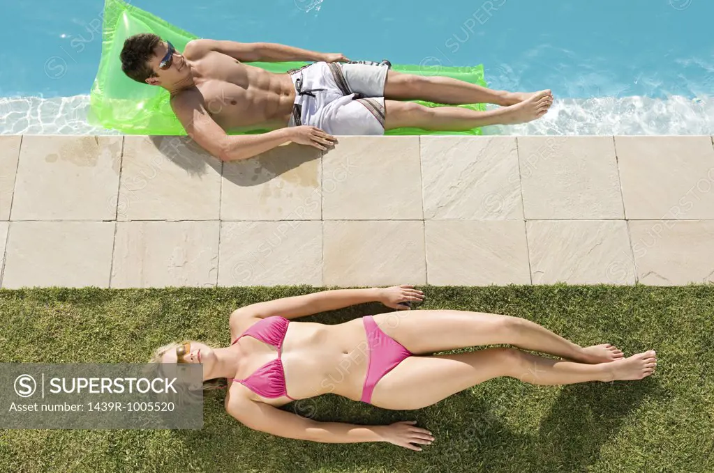 Couple sunbathing at the pool