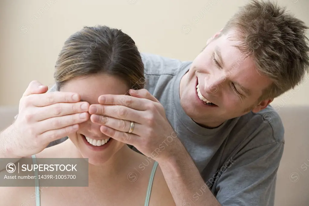 Man covering wife's eyes