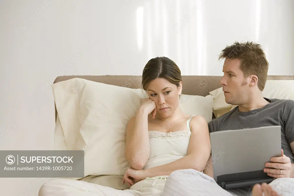 Wife annoyed at husband using laptop in bed