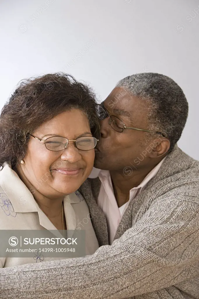Man kissing wife on the cheek