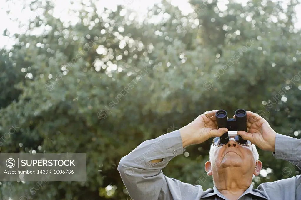 Senior man looking through binoculars