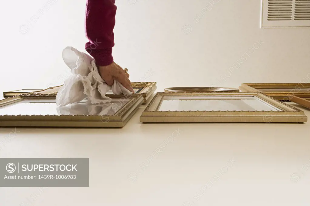 Woman dusting picture frames